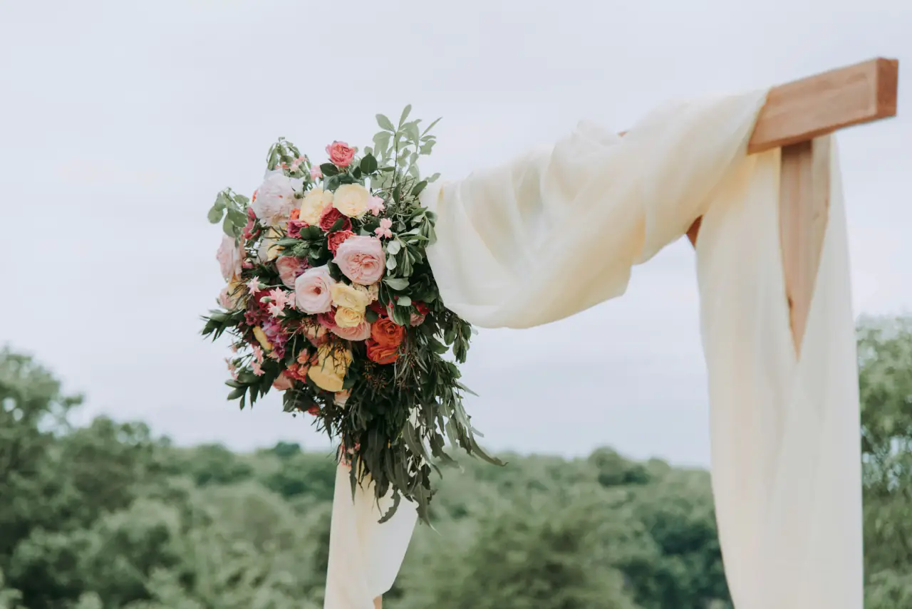 Bouquet on a draped wedding arch
